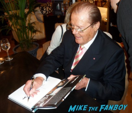 Roger Moore signing autographs for fans at his bond on bond book signing at harrod's in london rare signature promo