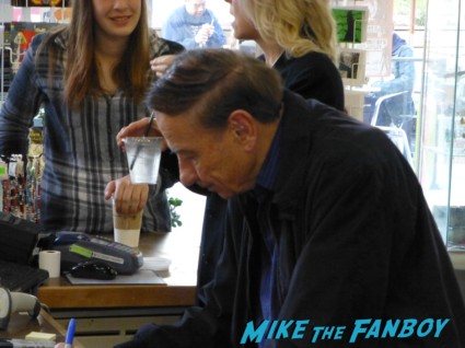 Richard M. Sherman signing autographs for fans and playing music at an instore signing
