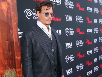 Johnny Depp on the red carpet at the Lone Ranger Movie Premiere signing autographs