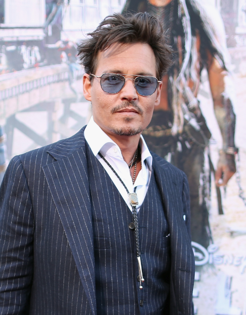 Johnny Depp on the red carpet at the Lone Ranger Movie Premiere signing autographs