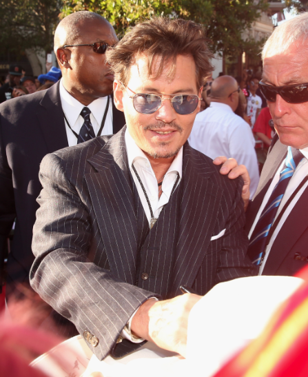 johnny depp signing autographs on the red carpet at the Lone Ranger Movie Premiere signing autographs