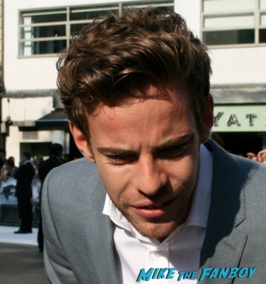Harry Treadaway signing autographs for fans at the uk premiere of The Lone Ranger